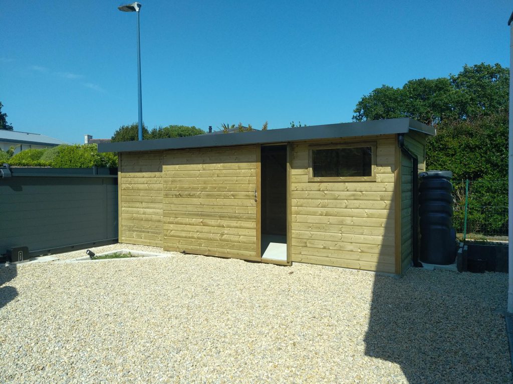 Abri en bois sur-mesure avec porte coulissante, fenêtre, gouttière et récupérateur d'eau