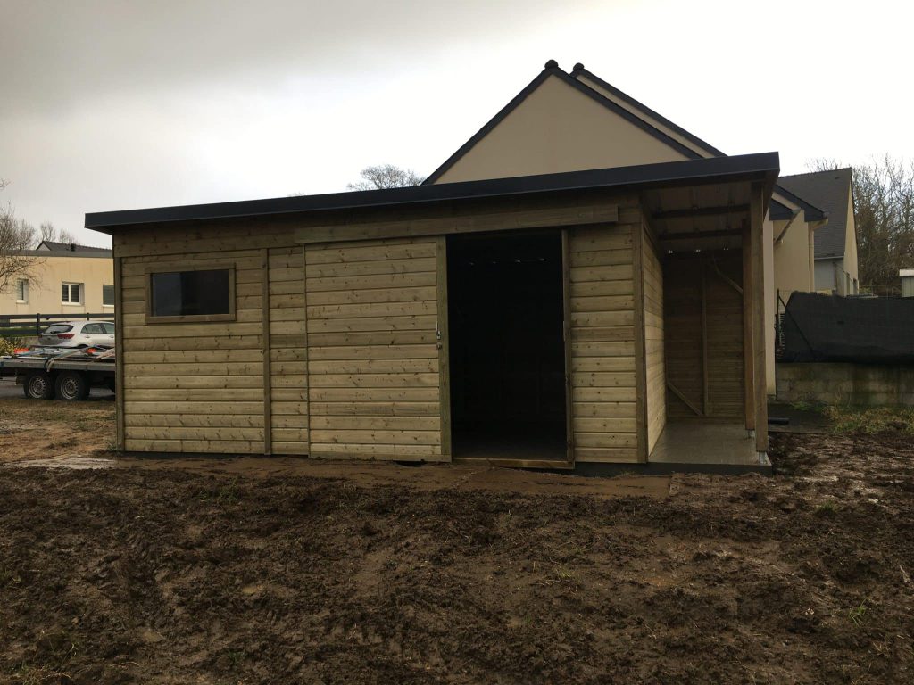 Abri en bois sur-mesure avec porte coulissante, fenêtre et bûcher